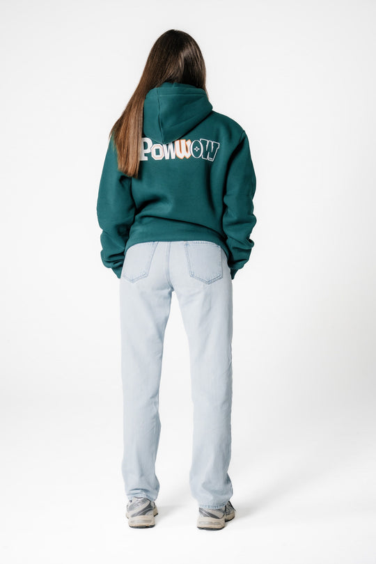 Rückansicht eines Models, das den dunkelgrünen POWWOW Signature Hoodie GREEN mit großem weiß-orangem Logo-Backprint trägt.