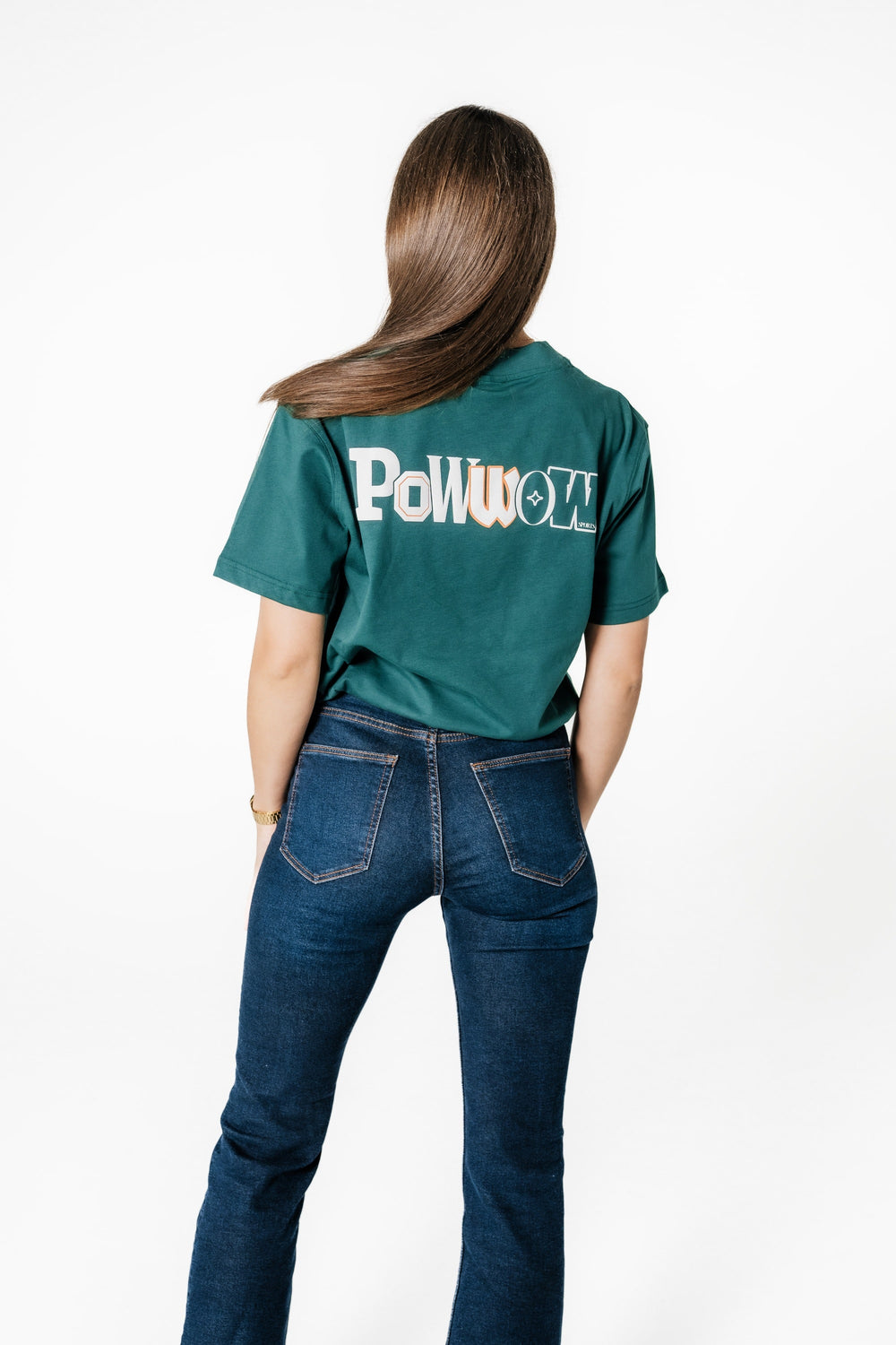 Rückansicht eines Models, das das POWWOW Backprint T-Shirt in Green (Teal) mit großem weiß-orangem Logo-Print trägt.